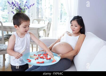 Modello rilasciato. Donna in stato di gravidanza (34 settimane) giocando con il figlio. Foto Stock