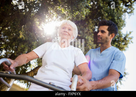 L'infermiera aiutando senior donna a camminare Foto Stock