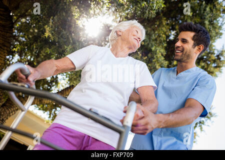 L'infermiera aiutando senior donna a camminare Foto Stock