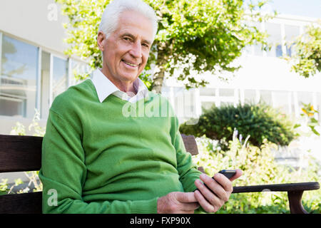 Senior che pongono l uomo con il suo smartphone Foto Stock