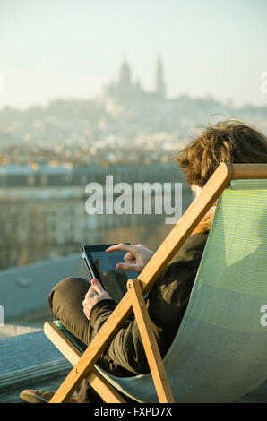 Uomo con tavoletta digitale sulla terrazza sul tetto Foto Stock