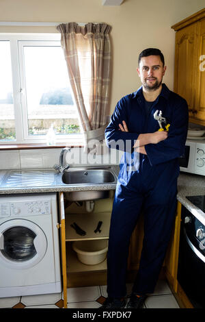 Ritratto di plumber in piedi in cucina Foto Stock