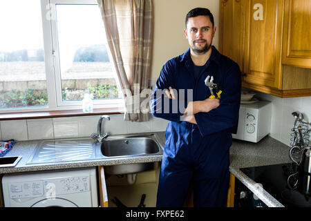 Ritratto di plumber in piedi in cucina Foto Stock