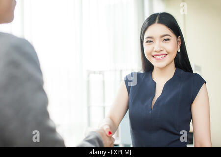 Bella asiatica imprenditrice sorridente e stringono le mani con altri proprietari Foto Stock