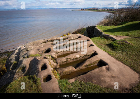 Insolito rock cut tombe accanto alle Rovine di San Patrizio Cappella affacciato sulla baia di Morecambe, Heysham, Lancashire, Regno Unito Foto Stock