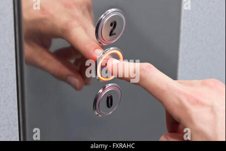 Premendo il pulsante di ascensore Foto Stock