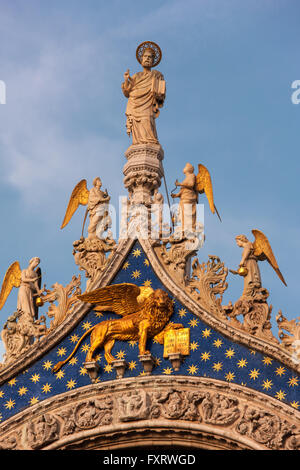 La Cattedrale di San Marco, Venezia, particolare della facciata. San Marco con gli angeli sopra il leone alato simbolo di Venezia e il san. Foto Stock