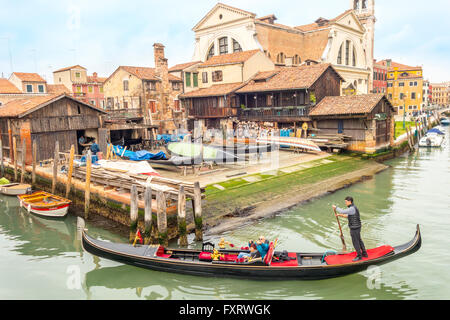 Venezia Italia. Gondola Veneziana sul Rio San Trovaso passando la gondola workshop cantiere Squero di San Trovaso nel sestiere di Dorsoduro Foto Stock