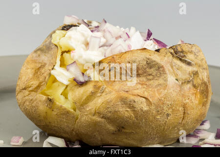 Patate al forno con cipolla rossa close up su piastra Foto Stock