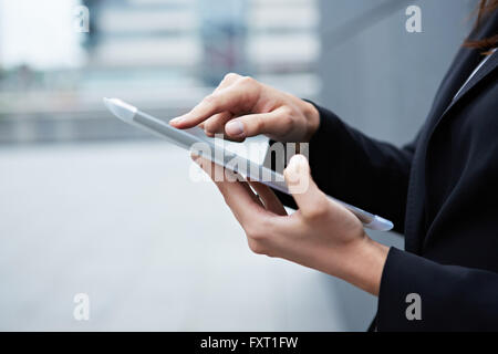 Dito indice toccando il touchscreen del tablet pc Foto Stock