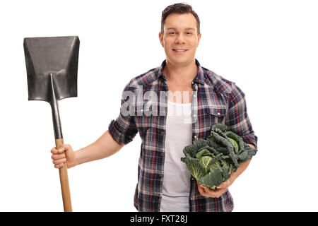 Lavoratore agricolo tenendo un cavolo verza e una pala isolati su sfondo bianco Foto Stock