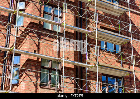 Lund, Svezia - 11 Aprile 2016: impalcature contro un rosso mattone edificio di appartamenti in corso di ristrutturazione. Foto Stock