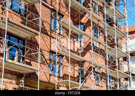 Lund, Svezia - 11 Aprile 2016: impalcature contro un rosso mattone edificio di appartamenti in corso di ristrutturazione. Foto Stock