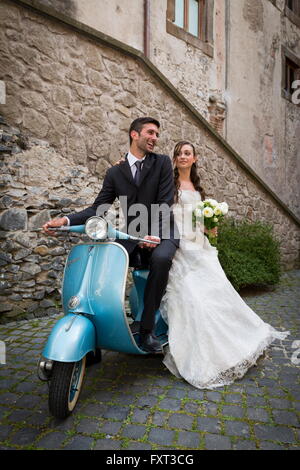 Sposa e lo sposo su un ciclomotore Vespa, Roma, Italia Foto Stock