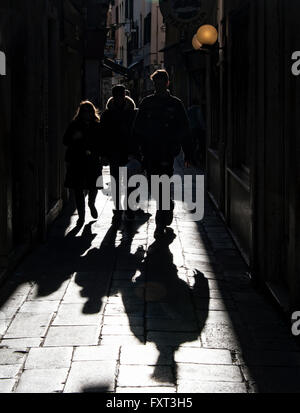 Pedoni e le loro ombre in un vicolo, back lit, Venezia, Veneto, Italia Foto Stock