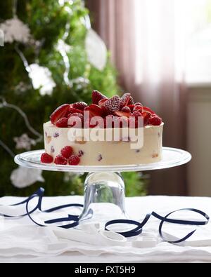 Charlotte russe decorate con fragole e lamponi sulla torta di vetro stand Foto Stock