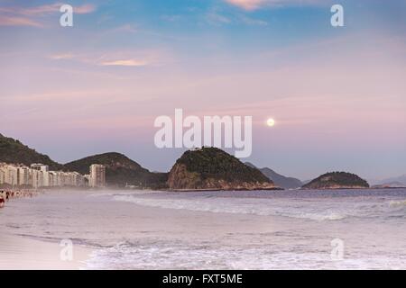 Onde sulla battigia e montagne di sera, Copacabana, Rio de Janeiro, Brasile Foto Stock