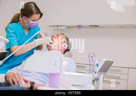 Dentista condurre un esame dentale sull uomo maturo Foto Stock