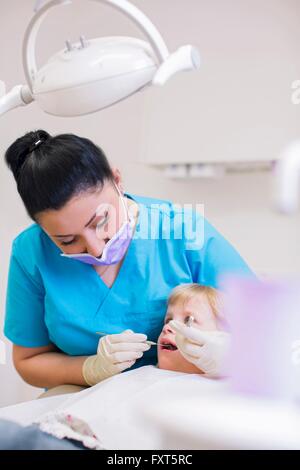 La ragazza di dentista sedia avente esame dentale Foto Stock