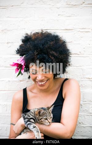 Ritratto di donna con fiore nei capelli, cat in armi Foto Stock