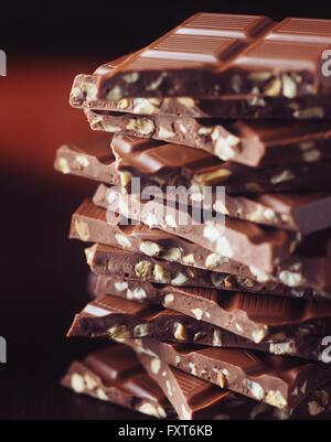 Pila di rotture di cioccolato con le nocciole, close-up Foto Stock