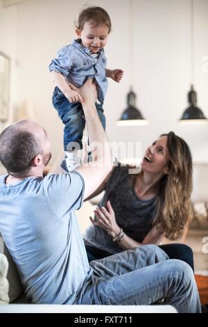 I genitori tenendo premuto fino a sorridere baby boy Foto Stock