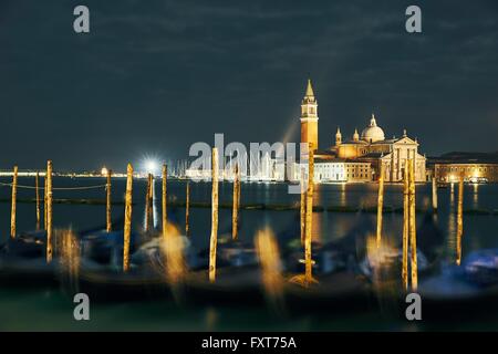 Gondole sfocata di fronte alla chiesa di San Giorgio Maggiore di notte, Venezia, Italia Foto Stock