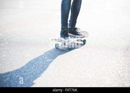 Gambe di maschile urbana finta di guidatore di skateboard skateboard su strada Foto Stock