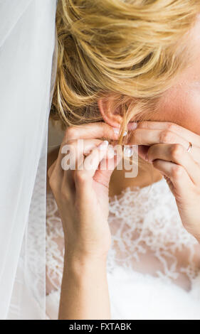 Bella Sposa gorgeous mettendo su Orecchini di lusso Foto Stock