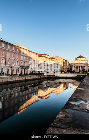 Sun va giù e vernici di colori sulla parete degli edifici di Trieste Foto Stock