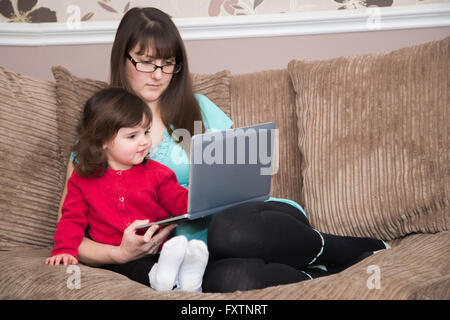 Madre e figlia che guarda un notebook Foto Stock