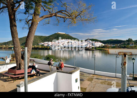 Il Portogallo, Algarve: Turisti alla riva del fiume Guadiana in Alcoutim guardando al villaggio spagnolo San Lucar del Guadiana Foto Stock