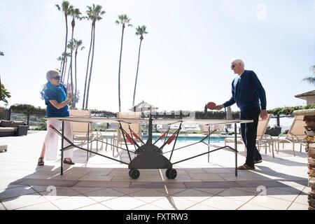 Coppia senior giocando a ping-pong, all'aperto Foto Stock
