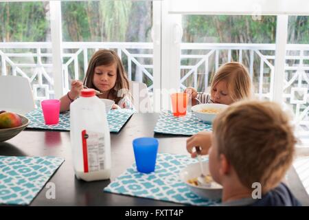 I fratelli al tavolo da pranzo di mangiare la prima colazione Foto Stock