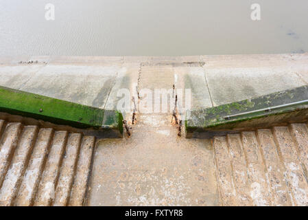 Vecchia coperta di alghe passi concreti che conducono in basso verso il mare a Blackpool, Lancashire Foto Stock