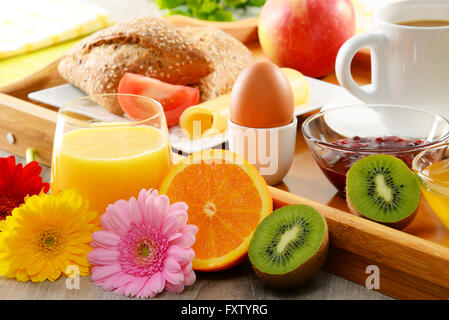 La colazione sul vassoio servita con caffè, succo d'arancia, uova, panini e miele. Dieta bilanciata. Foto Stock