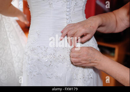 Madre contribuisce per la sposa abito di usura nel giorno di nozze Foto Stock