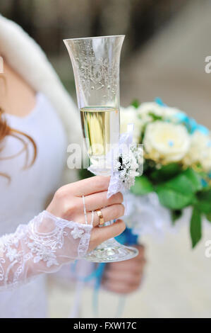 Sposa è azienda bouquet nuziali e bicchiere di champagne Foto Stock