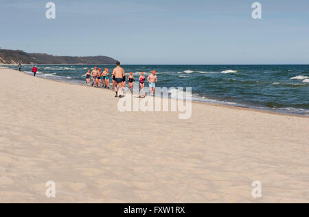 Inverno nuotatori che corre lungo la spiaggia di Wladyslawowo seashore, Polonia, Europa, persone in fase di riscaldamento, active sport nel Mar Baltico Foto Stock