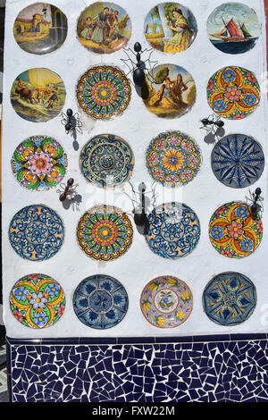 Display del dipinto a mano le piastre in ceramica e metallo formiche decorare la parete di un negozio di souvenir, Gata de Gorgos, Valencia, Spagna. Foto Stock