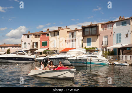 I turisti in una barca passando waterfront case, Port Grimaud, Cote D'Azur, in Francia Foto Stock