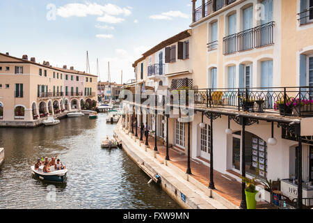 I turisti in una barca passando waterfront edifici, Port Grimaud, Cote D'Azur, in Francia Foto Stock