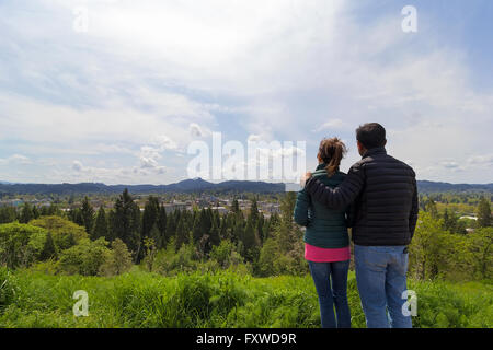 Coppia al top della spellatrice Butte Park gode di vista del centro di Eugene, Oregon su una bella giornata Foto Stock