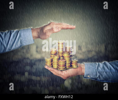 L'uomo hans trattenere e proteggere la moneta in euro di denaro Foto Stock