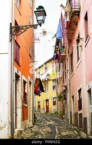 Una stretta strada nel quartiere di Alfama a Lisbona, Portogallo Foto Stock