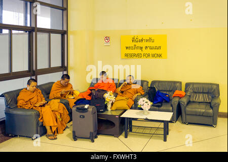 Asia. Il sud-est asiatico. Thailandia. Ubon Ratchathani Aeroporto. I monaci buddisti seduto su un posto riservato. Foto Stock