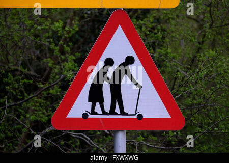 Tewkesbury, nel Gloucestershire, Regno Unito, 19 aprile 2016. Un funzionario Highway Traffic Sign è stata alterata da una persona sconosciuta. Il segno che sta per un fragile (o non vedenti o disabili se mostrato) pedoni probabilità di attraversare la strada, mostra un curvò giovane a piedi con un bastone. Il segno mostra ora le due figure su un micro-scooter. Il segno che è situato sulla A438 tra Tewkesbury e Ledbury, Gloucesteshire, UK. Negli ultimi anni i gruppi di campagna hanno contestato il sito web ufficiale di immagine sul segno come credono che travisa la eldery. Credito: Gavin Crilly/Alamy Live News Foto Stock