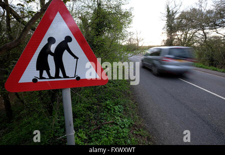 Tewkesbury, nel Gloucestershire, Regno Unito, 19 aprile 2016. Un funzionario Highway Traffic Sign è stata alterata da una persona sconosciuta. Il segno che sta per un fragile (o non vedenti o disabili se mostrato) pedoni probabilità di attraversare la strada, mostra un curvò giovane a piedi con un bastone. Il segno mostra ora le due figure su un micro-scooter. Il segno che è situato sulla A438 tra Tewkesbury e Ledbury, Gloucesteshire, UK. Negli ultimi anni i gruppi di campagna hanno contestato il sito web ufficiale di immagine sul segno come credono che travisa la eldery. Credito: Gavin Crilly/Alamy Live News Foto Stock