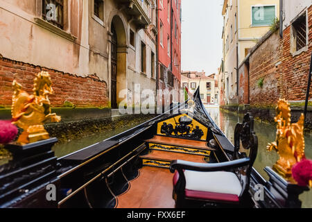 Vista prospettica dall'interno una gondola passare attraverso i canali veneziani. Foto Stock