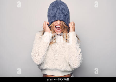 Ritratto di bella donna bionda in bianco in maglione bianco e blu hat Foto Stock